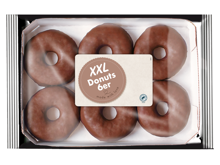 Sešas lielas šokolādes virtuļi iepakojumā, ar etiķeti „XXL Donuts 6er made with love“.