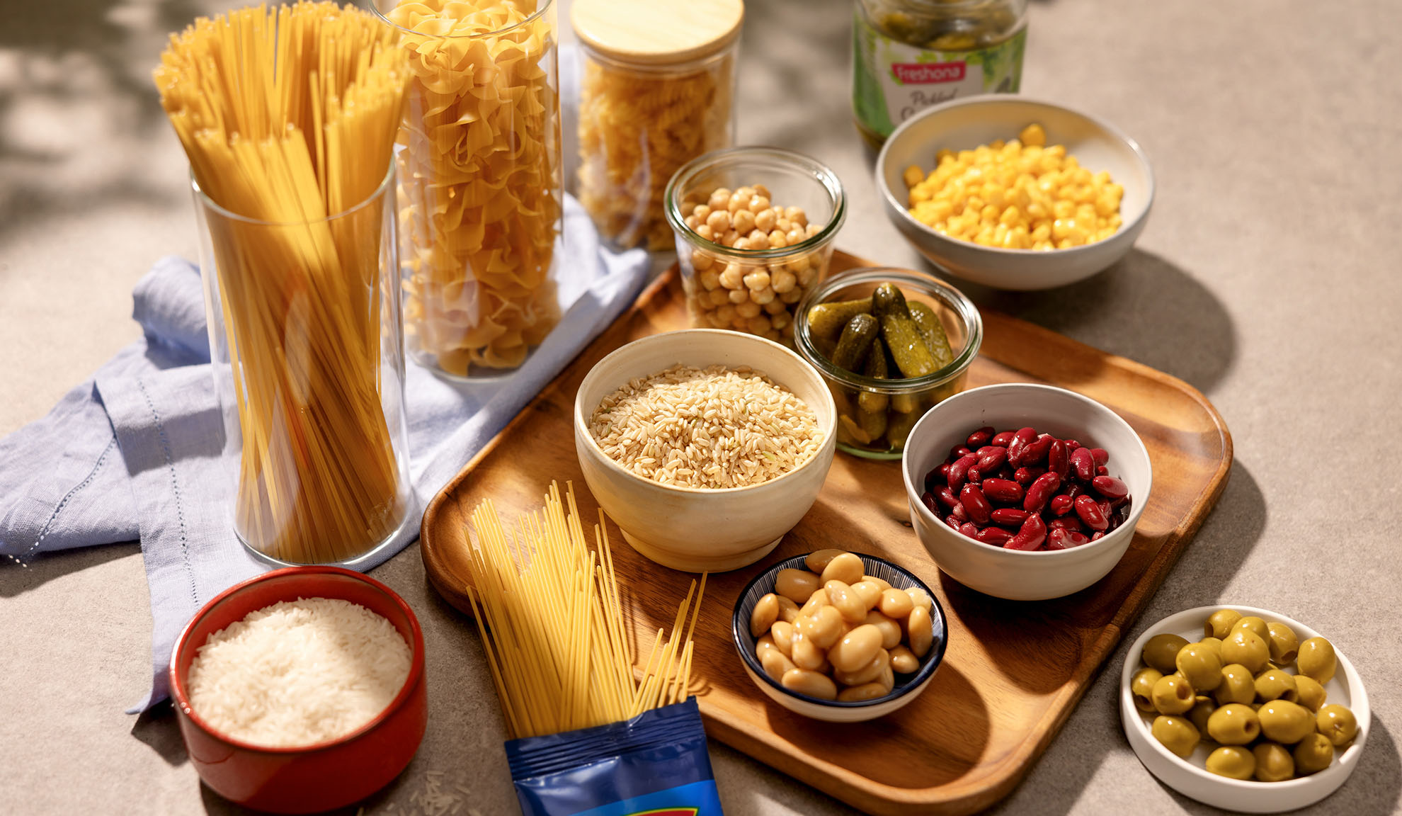 Sausās pastas, rīsu, aunazirņu, pupiņu, kukurūzas, marinētu gurķu un olīvu sortiments.