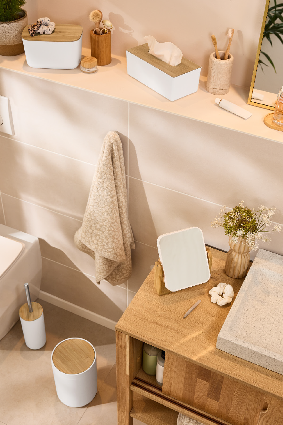 Vannas istabas piederumi bambusa un baltā krāsā, ieskaitot salvešu kastīti un atkritumu tvertni.