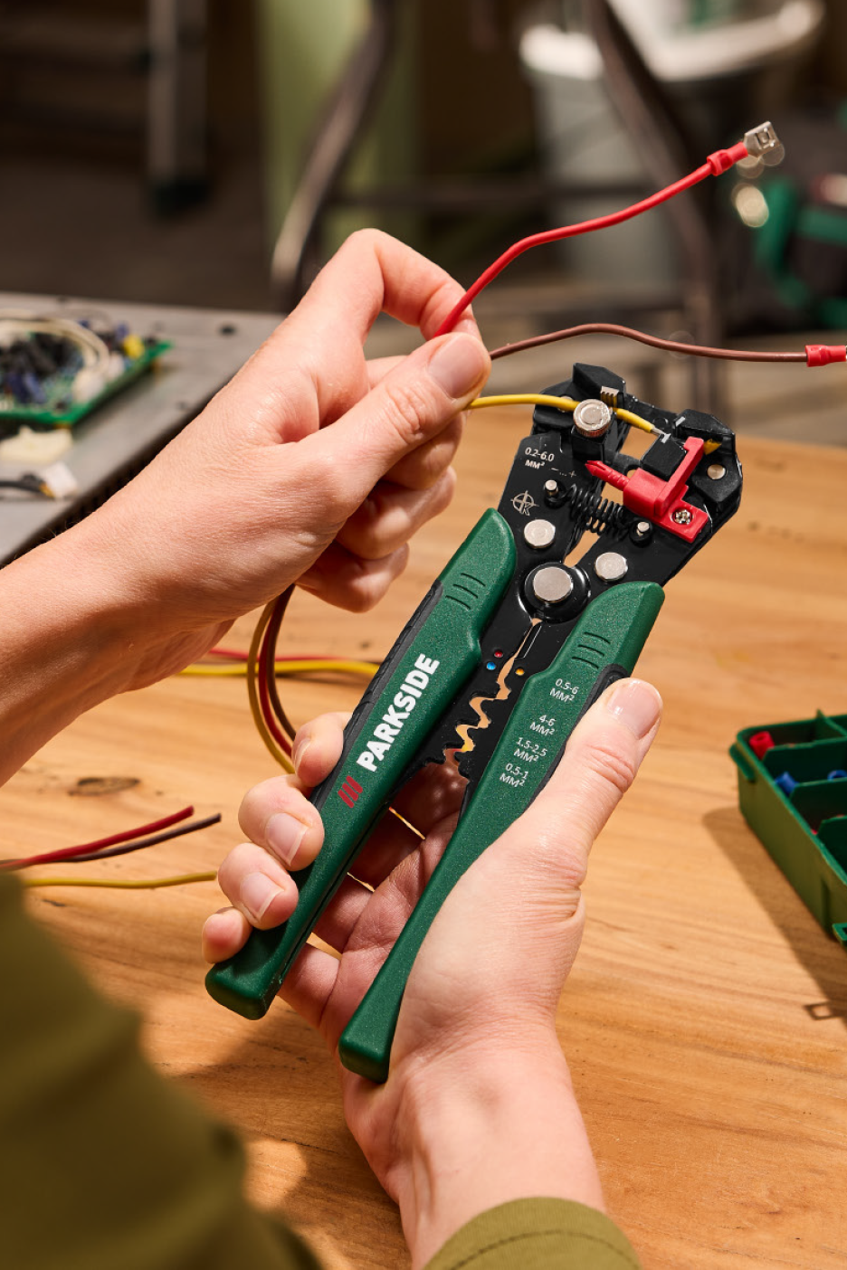 Tuvplāns ar rokām, kas izmanto automātisko vadu noņēmēju vadu attīrīšanai.