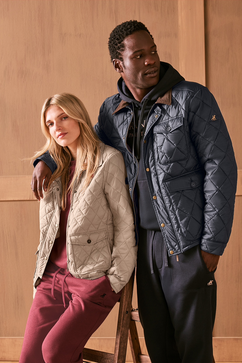 Vīrietis un sieviete stepētās jakās un sporta biksēs.