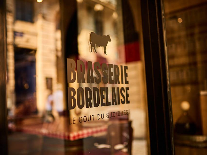 Brasserie Bordelaise izkārtne ar govs siluetu un tekstu „Le Goût du Sud-Ouest“.
