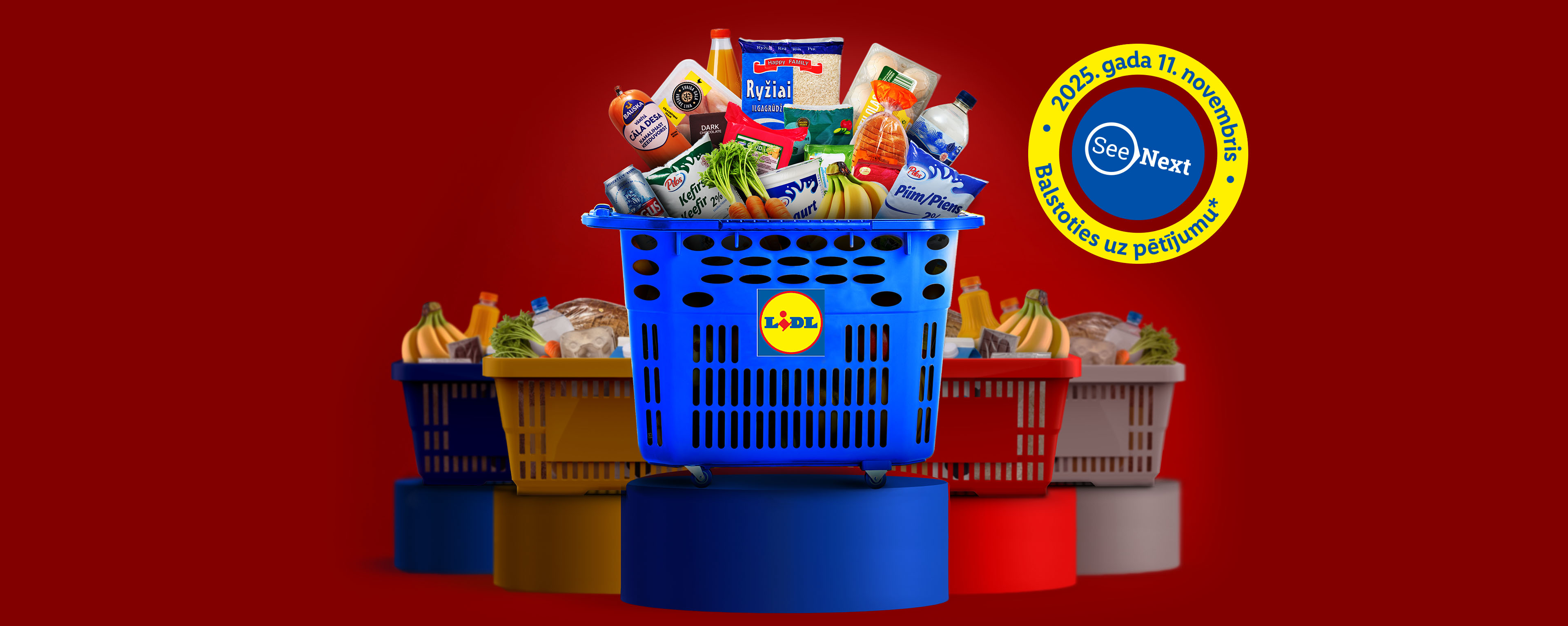 Lidl iepirkumu grozs ar pārtikas precēm, piemēram, rīsiem, kefīru, pienu, desu un banāniem, uz sarkana fona.