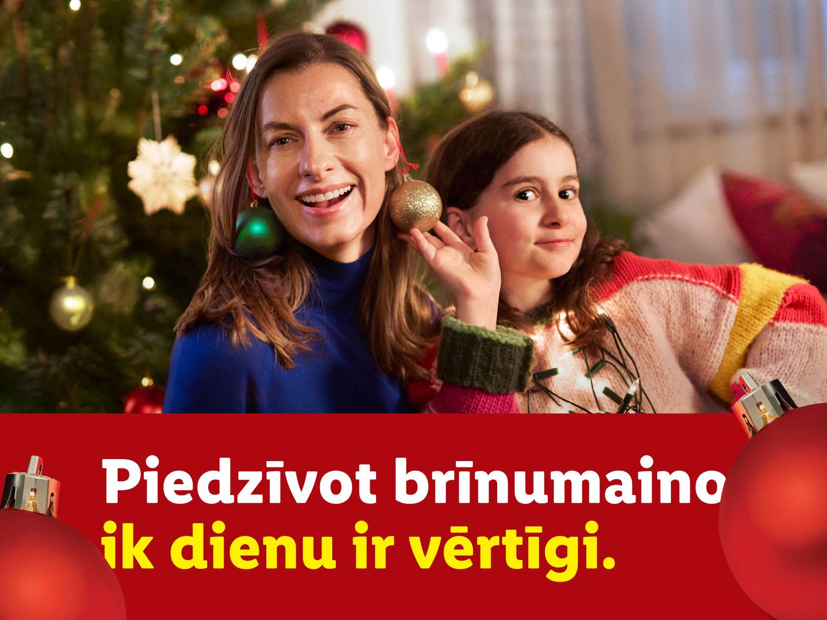 Māte un meita ar Ziemassvētku rotājumiem, teksts: «Piedzīvot brīnumaino ik dienu ir vērtīgi».