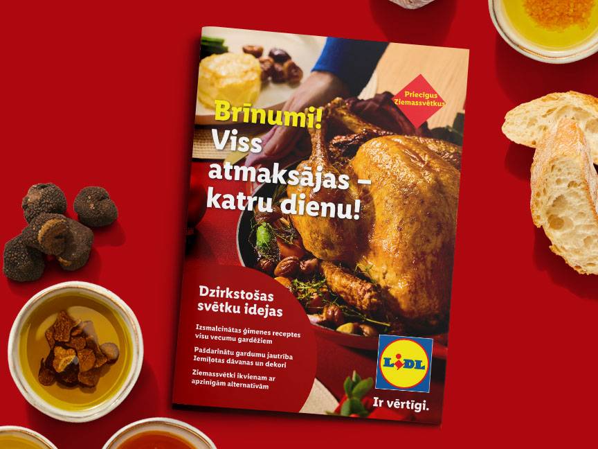 Lidl Ziemassvētku buklets ar ceptu vistu, trifelēm, sēnēm un maizi uz sarkana fona.