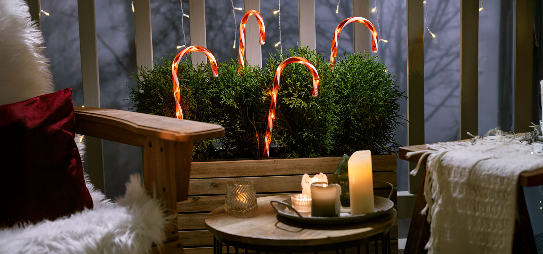 Рождественский балкон с креслом, свечами и леденцами.