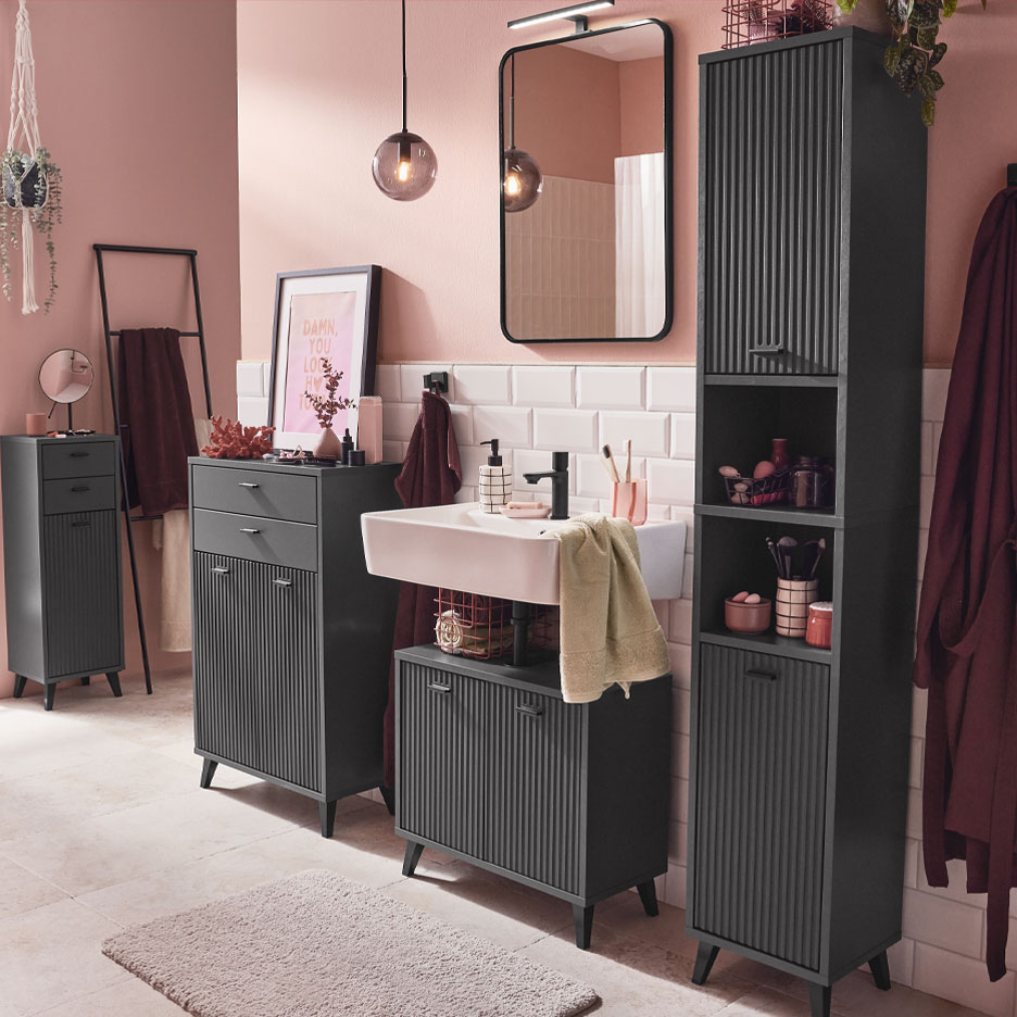 Современная ванная комната с темно-серой мебелью и розовыми акцентами.