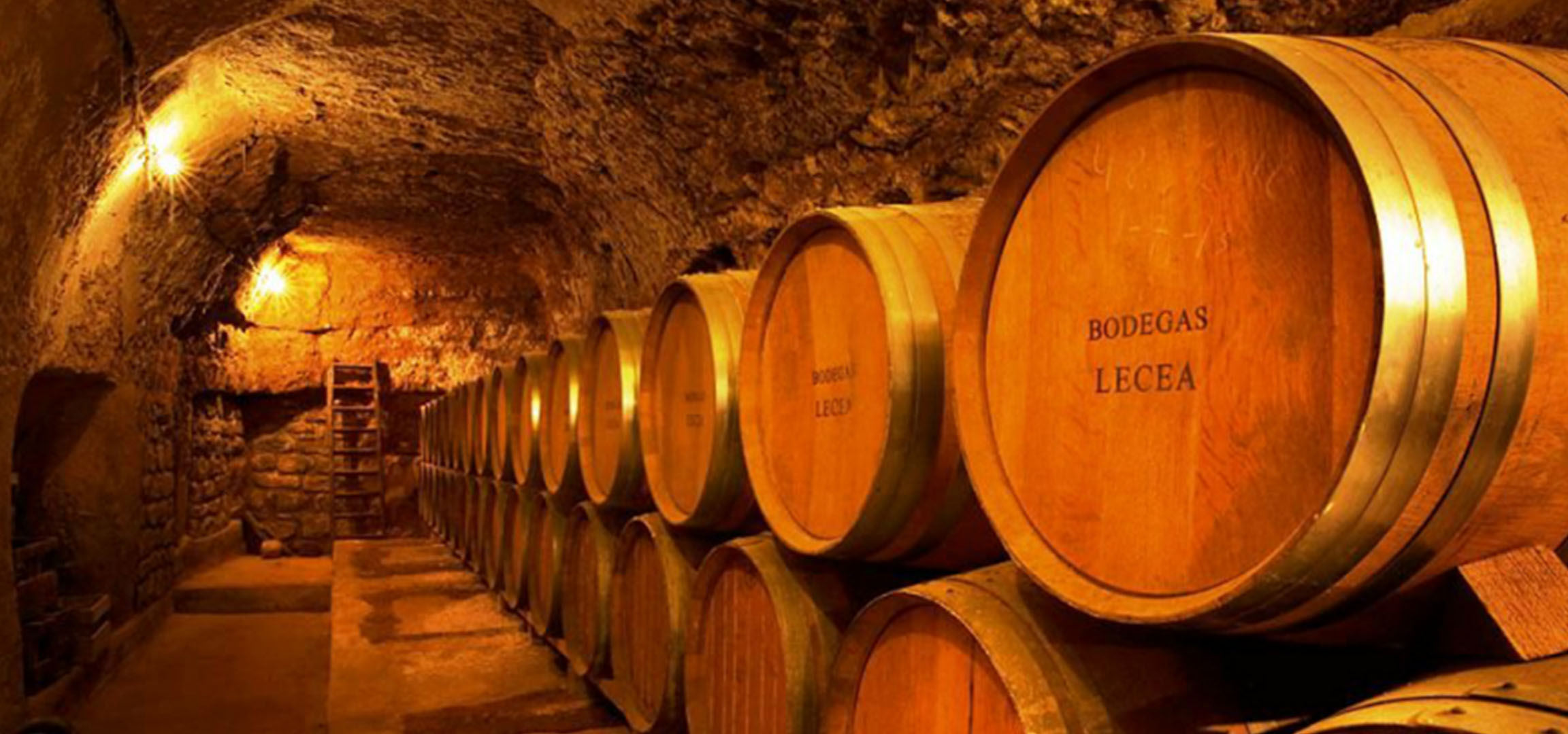 Vīna pagrabs ar koka mucām, dažas marķētas ar „BODEGAS LECEA”