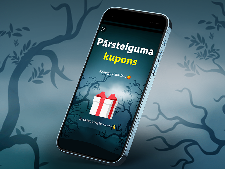 Viedtālrunis ar pārsteiguma kuponu Helovīnam uz spocīgu koku fona.