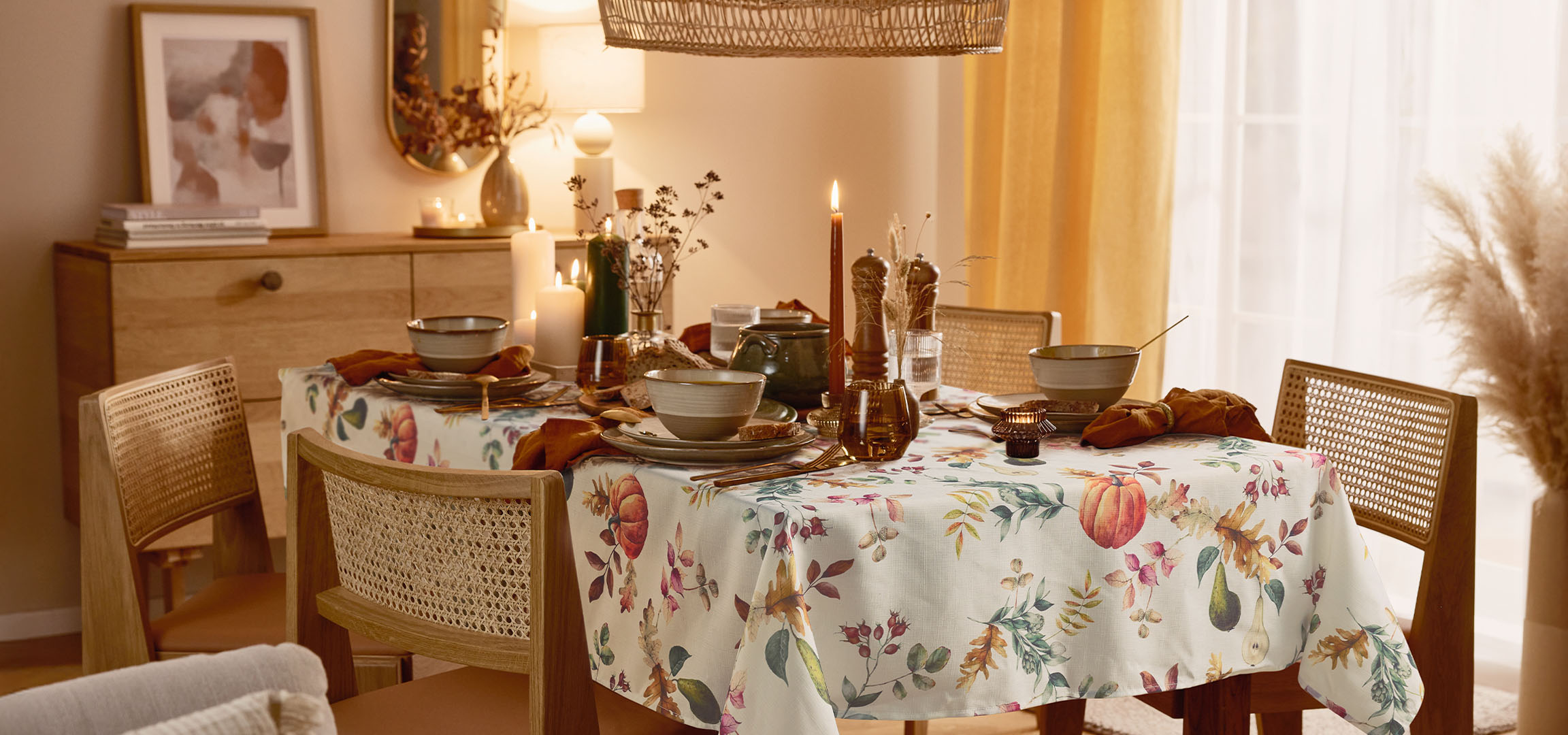 Столовая с накрытым столом, цветочной скатертью и теплым освещением.