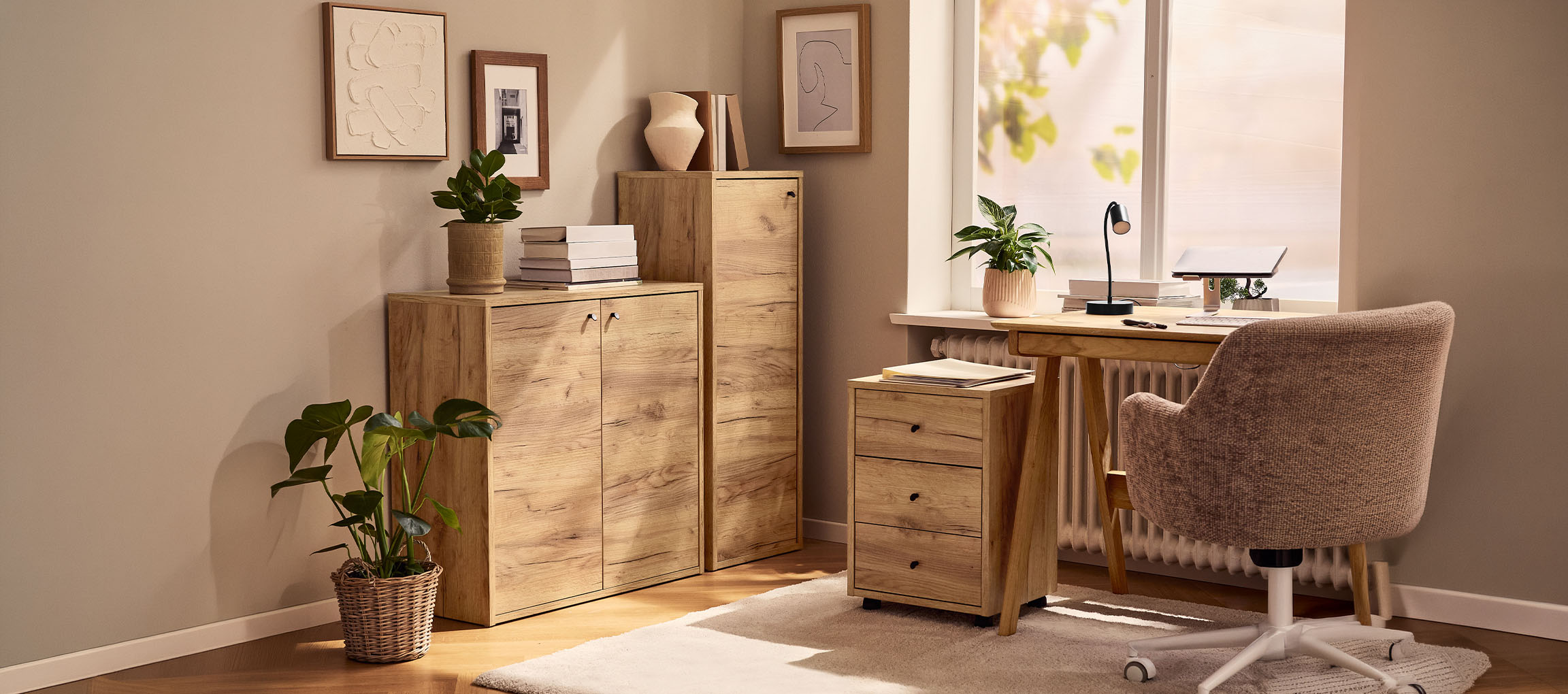 Mājas birojs ar koka skapjiem, galdu un krēslu, dekorēts ar augiem un gleznām.