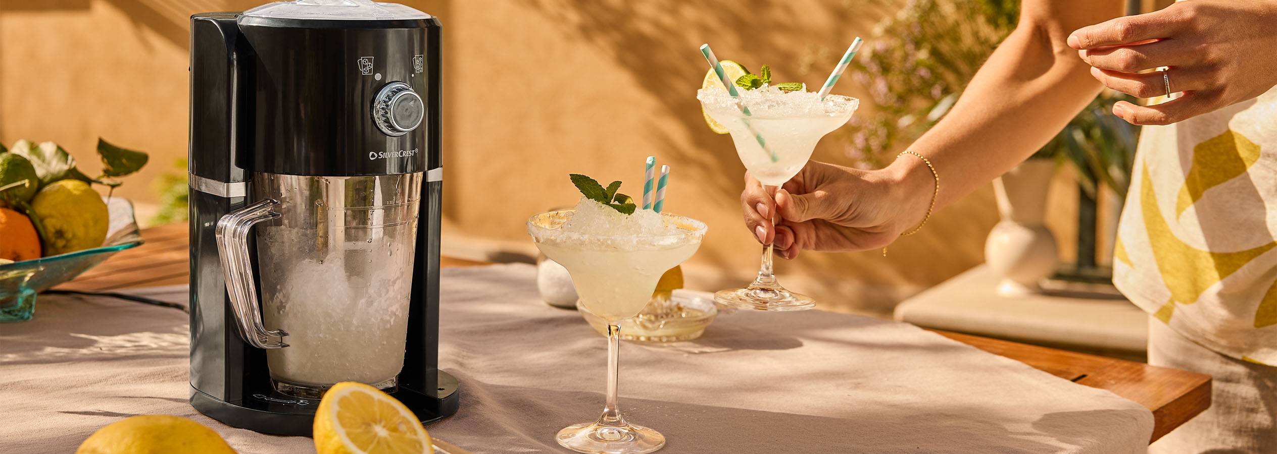 SilverCrest ledus sasmalcinātājs un divi margaritas kokteiļi saulrieta gaismā.